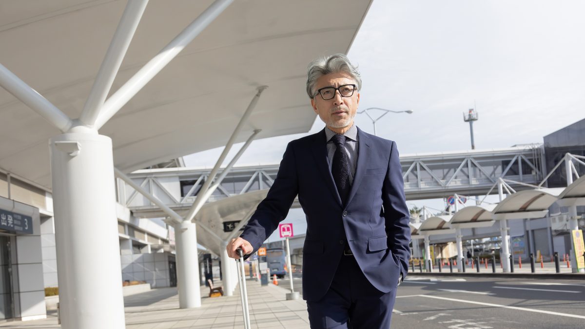 スーツケースを引いて空港を歩く人