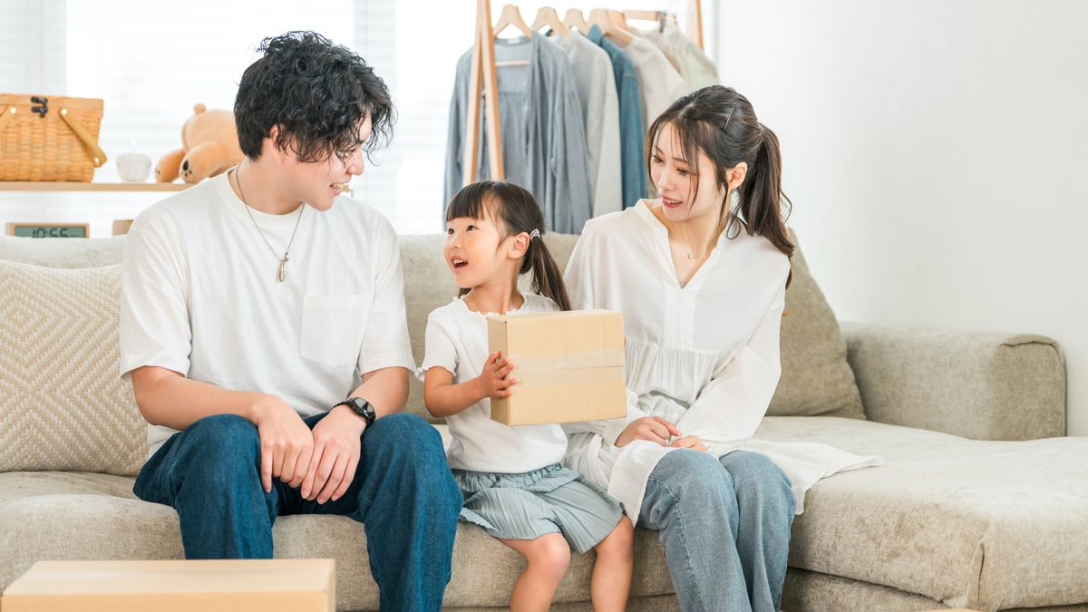 荷造りをした段ボールを囲む家族